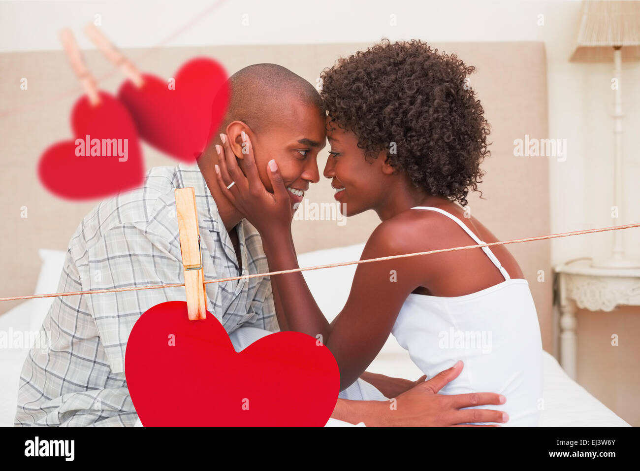 Composite image of happy couple showing affection on bed Stock Photo