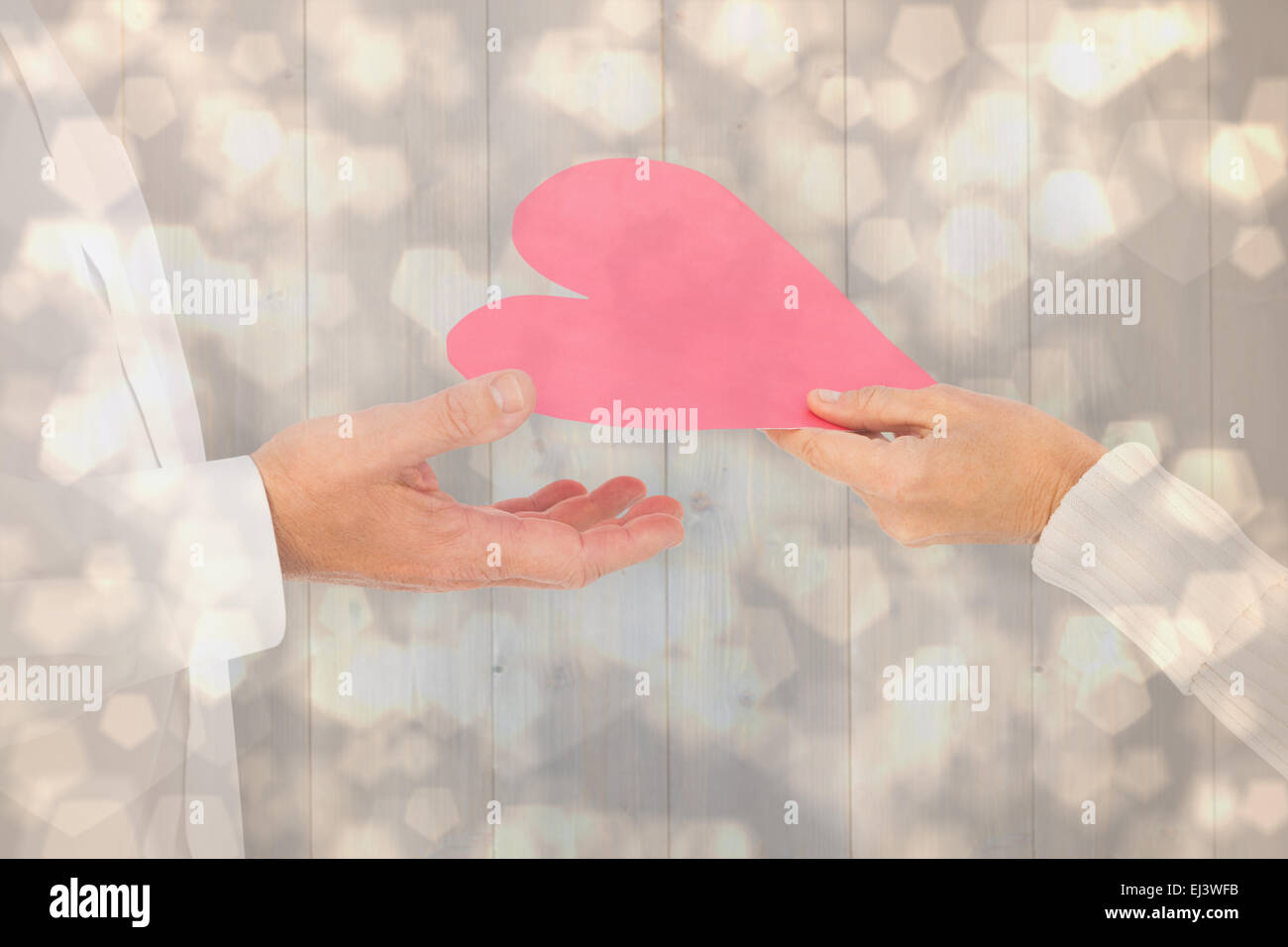 Composite image of woman handing man a paper heart Stock Photo
