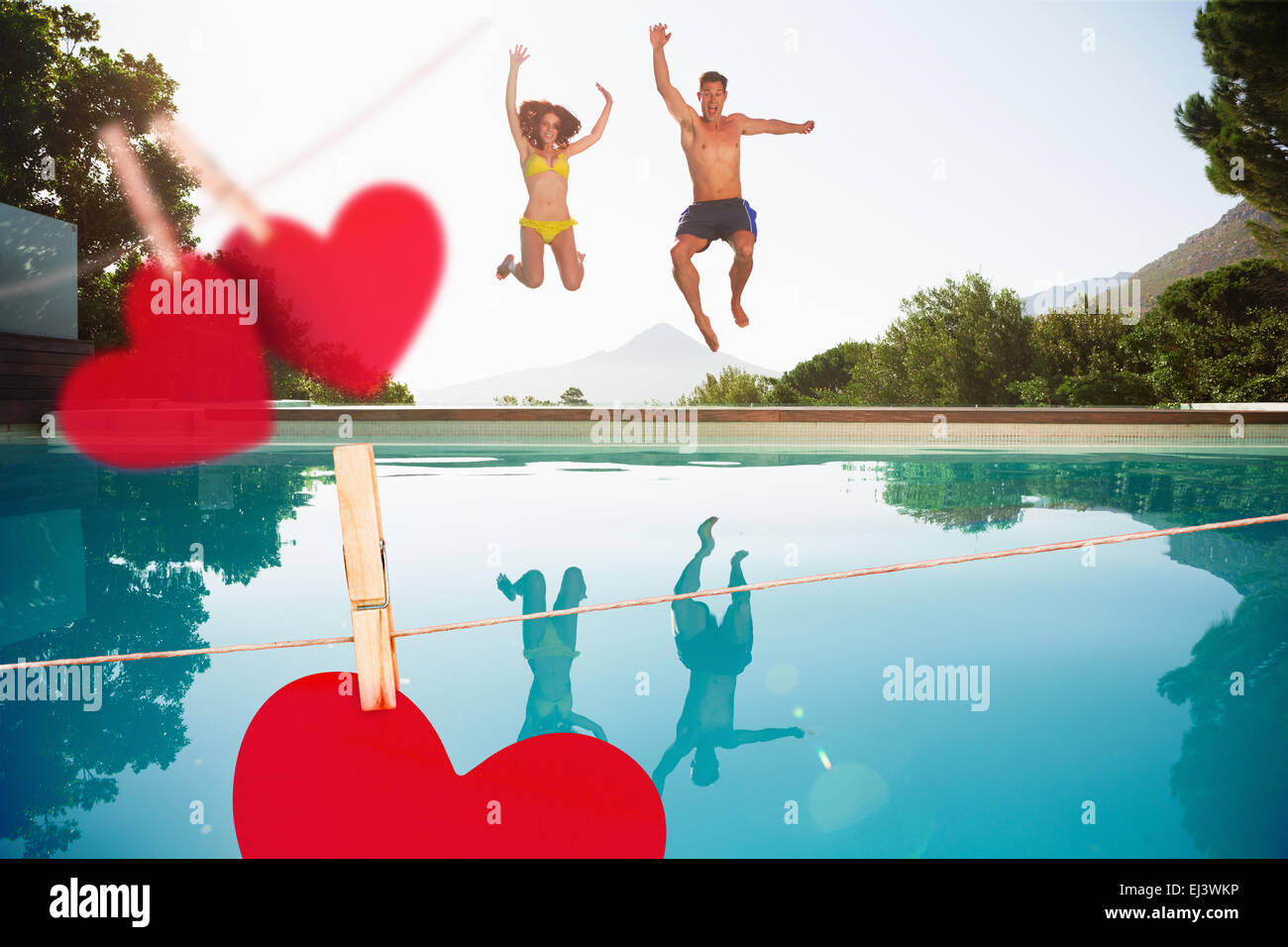Composite image of cheerful couple jumping into swimming pool Stock Photo