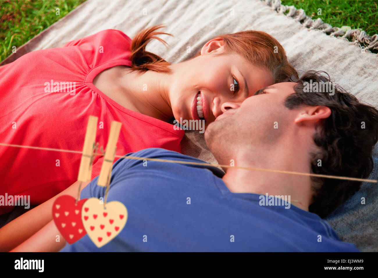 Composite image of woman looking into her friends eyes while lying on a quilt Stock Photo