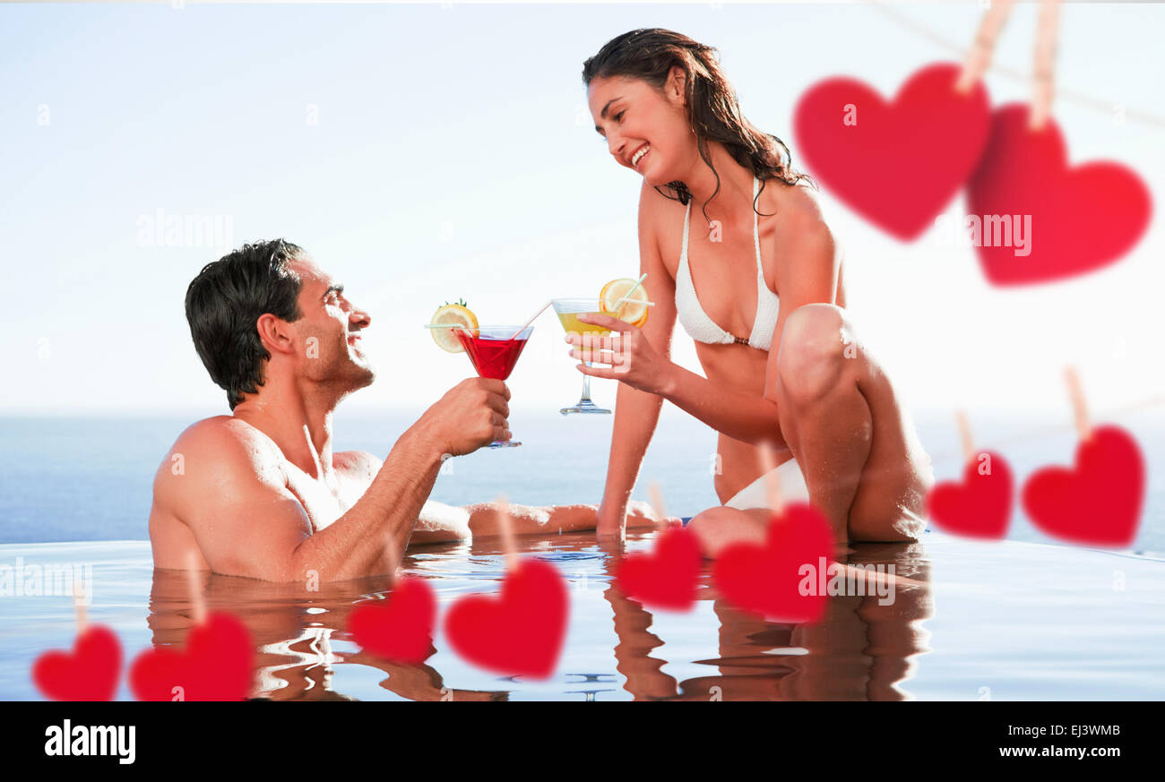 Composite image of couple having cocktails in the pool Stock Photo