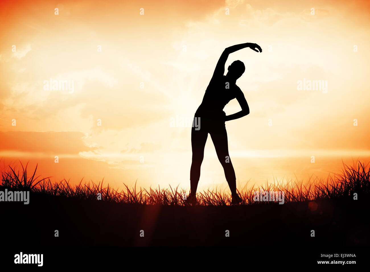 Composite image of fit brunette stretching rear view Stock Photo