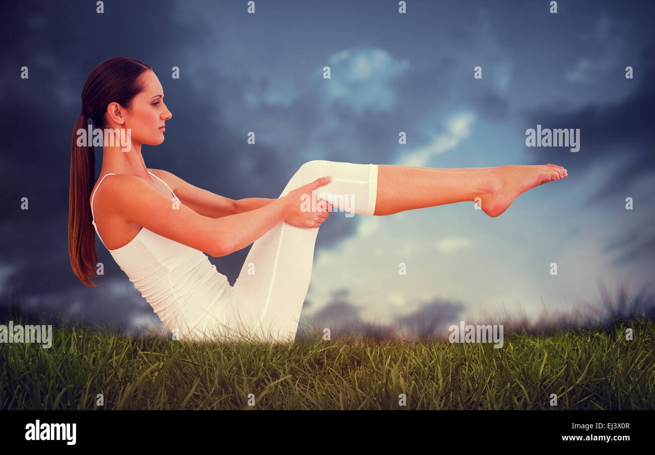 Composite image of toned woman doing the boat pose in fitness studio Stock Photo