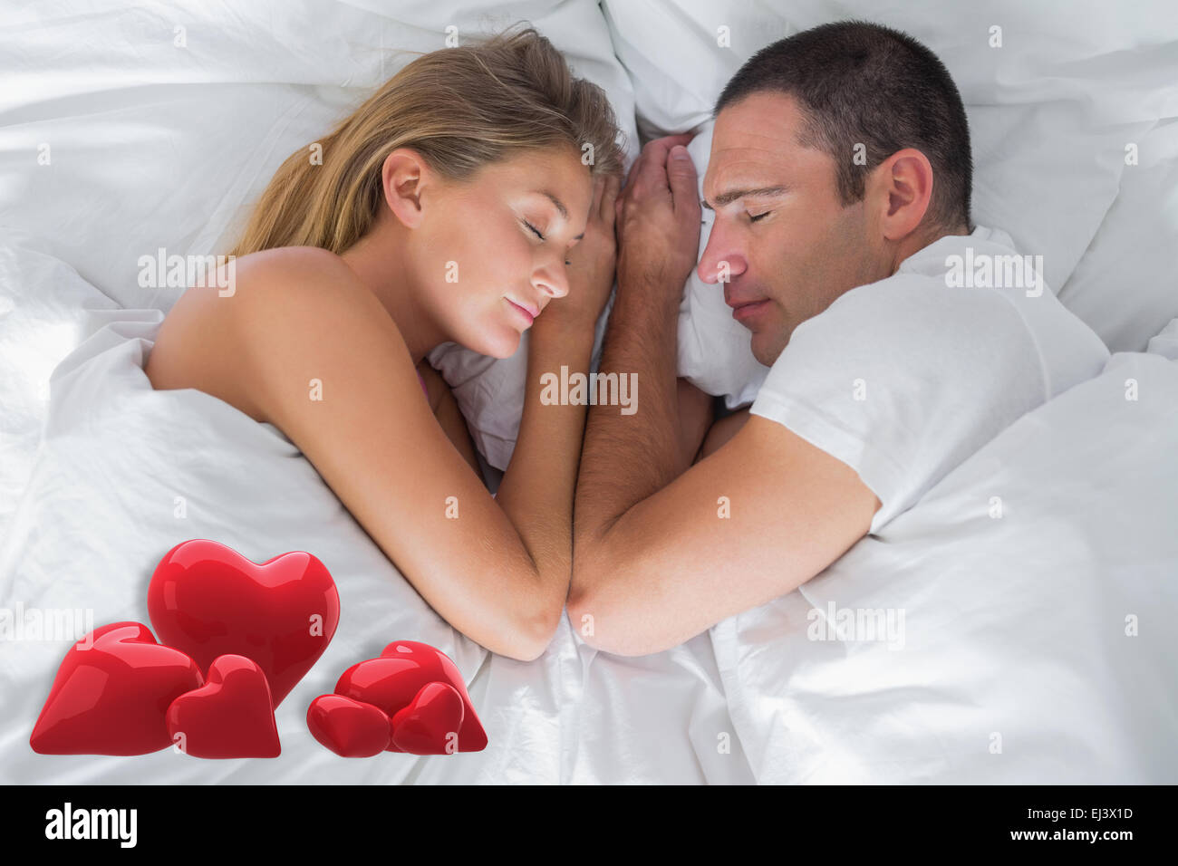 Composite image of cute couple lying asleep in bed Stock Photo