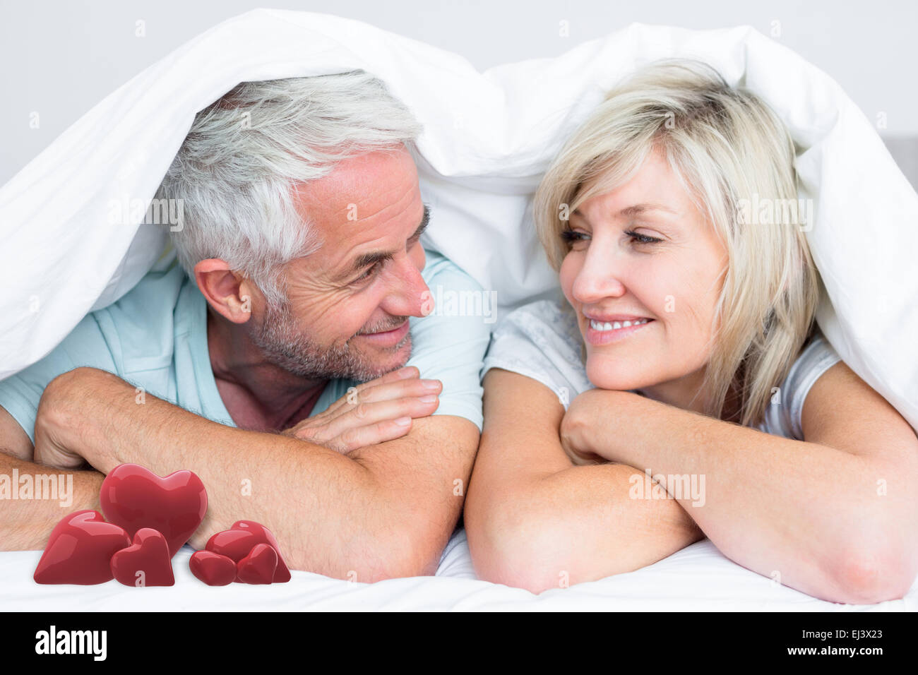 Composite image of closeup of a mature couple lying in bed Stock Photo