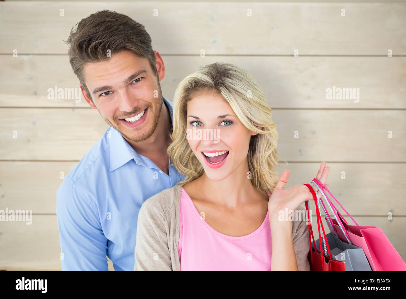 Composite image of attractive young couple holding shopping bags Stock Photo
