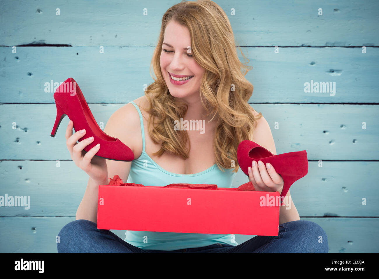 Composite image of blonde woman discovering shoes in a gift box Stock Photo