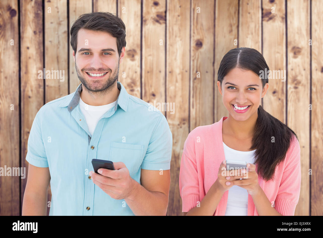 Composite image of happy couple sending text messages Stock Photo