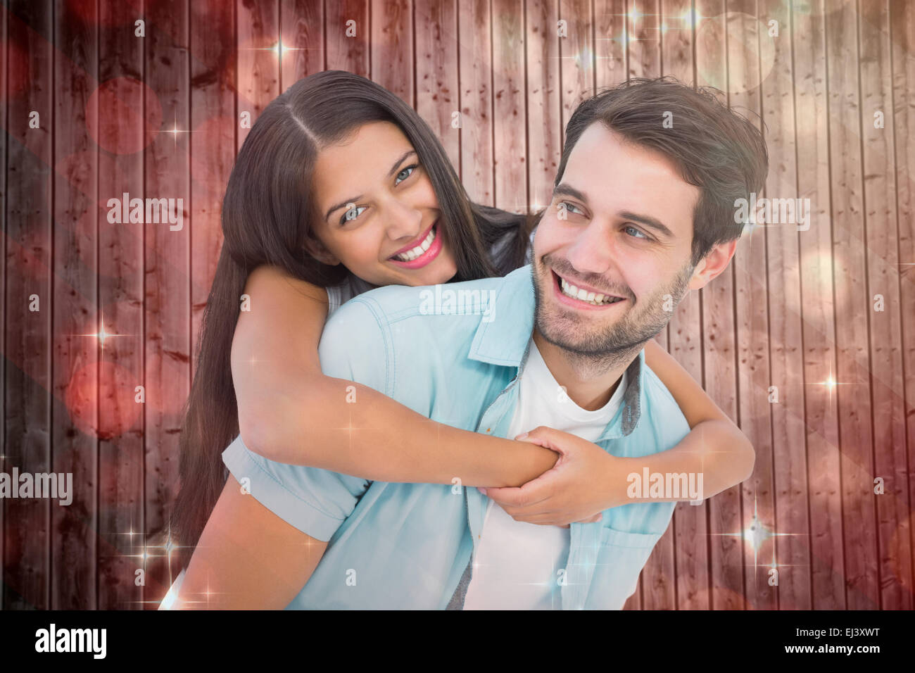 Composite image of happy casual man giving pretty girlfriend piggy back Stock Photo