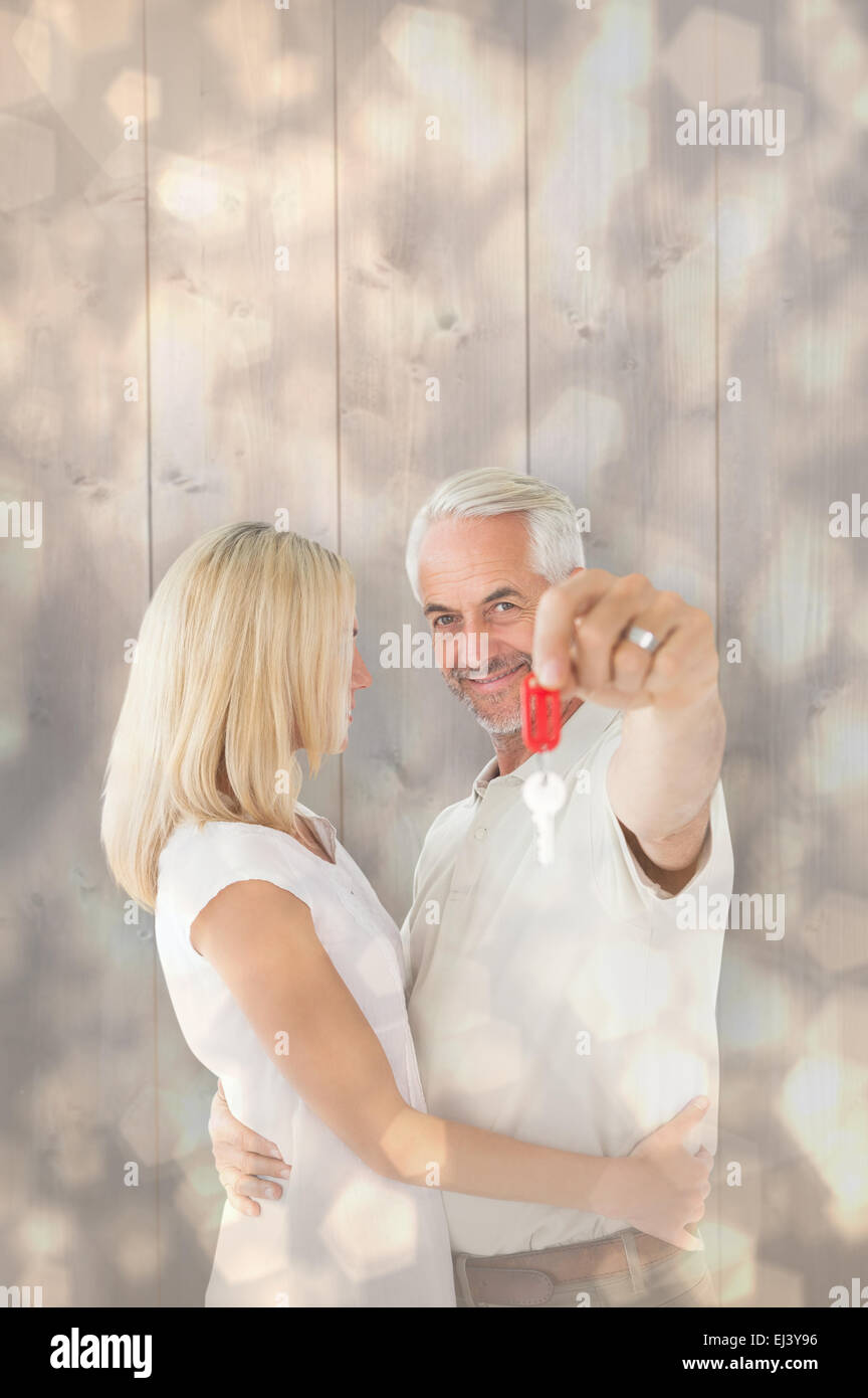 Composite image of happy couple showing their new house key Stock Photo ...