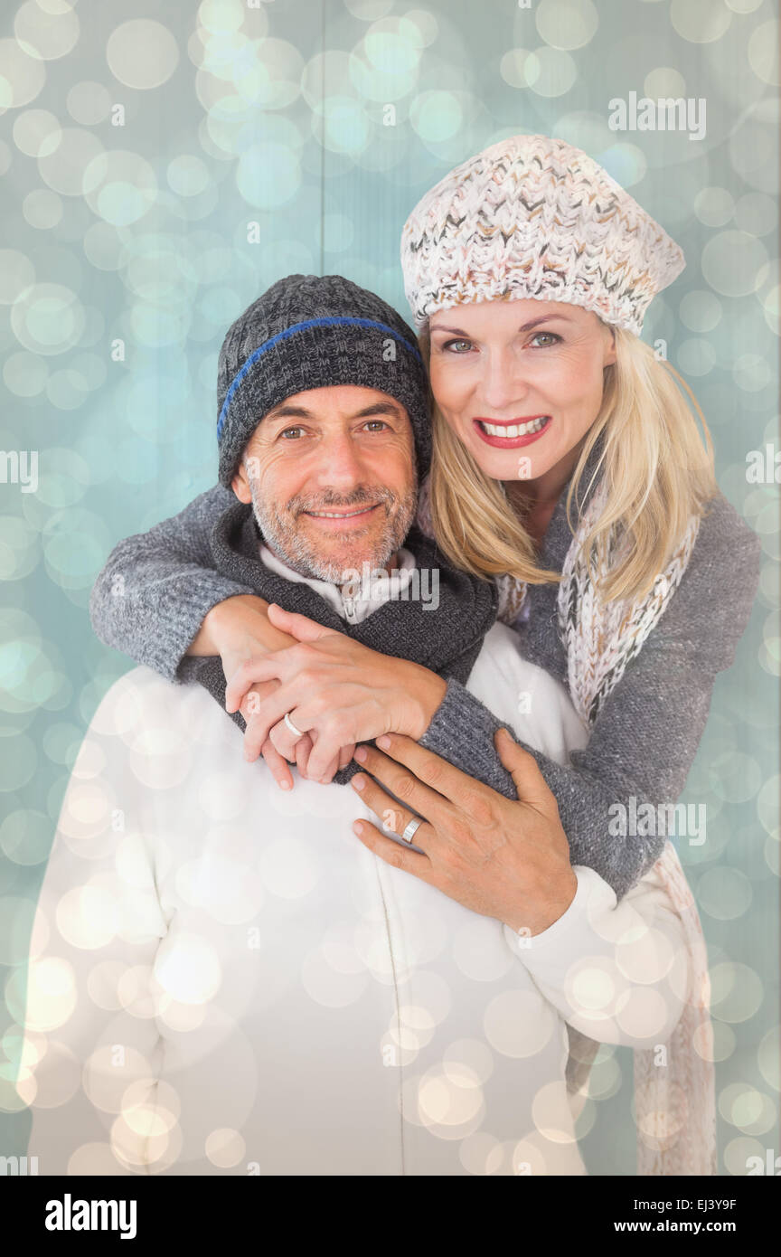 Composite image of happy couple in winter fashion embracing Stock Photo