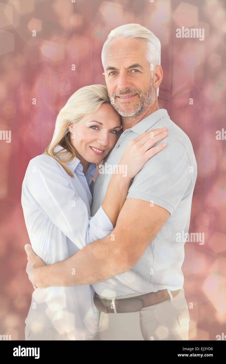 Composite image of happy couple standing and smiling at camera Stock Photo