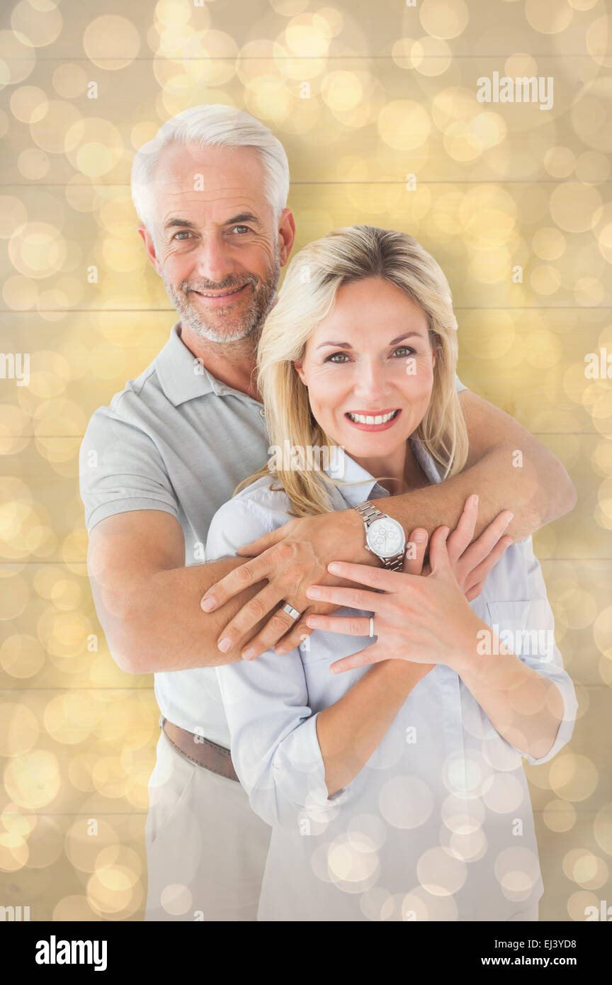 Composite image of happy couple smiling at camera and embracing Stock Photo