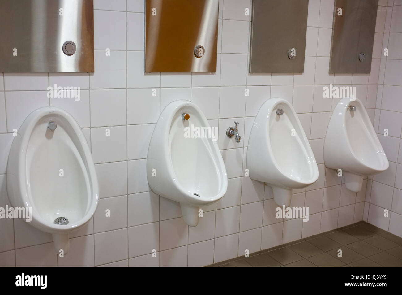 Line of urinals in the mens toilet. Stock Photo