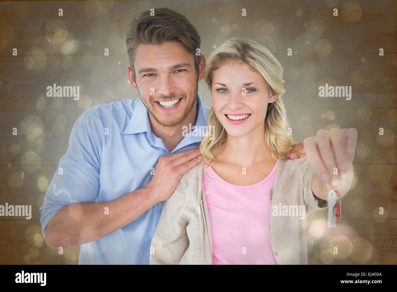 Composite image of attractive young couple showing new house key Stock