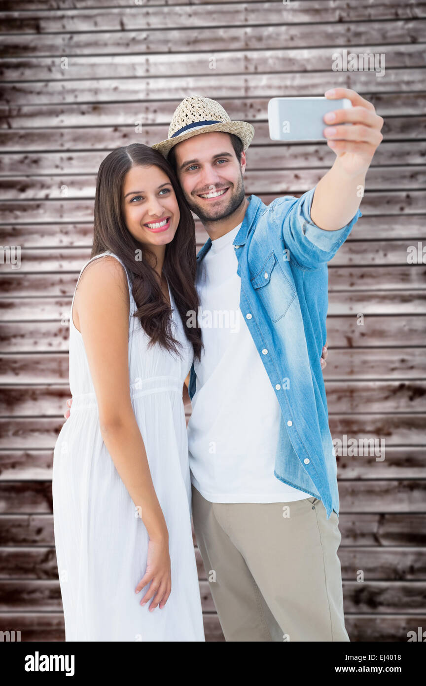 Composite image of happy hipster couple taking a selfie Stock Photo
