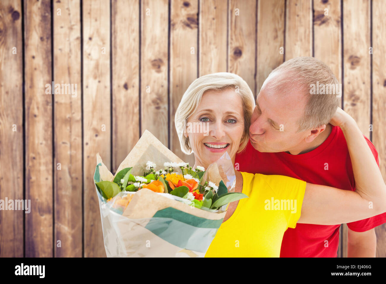 Composite image of mature man kissing his partner holding flowers Stock Photo