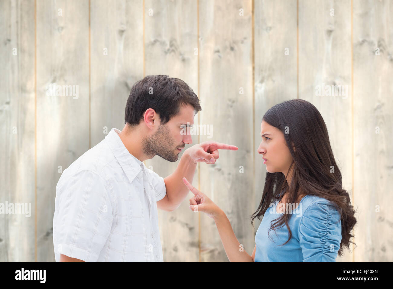 Composite image of angry couple pointing at each other Stock Photo