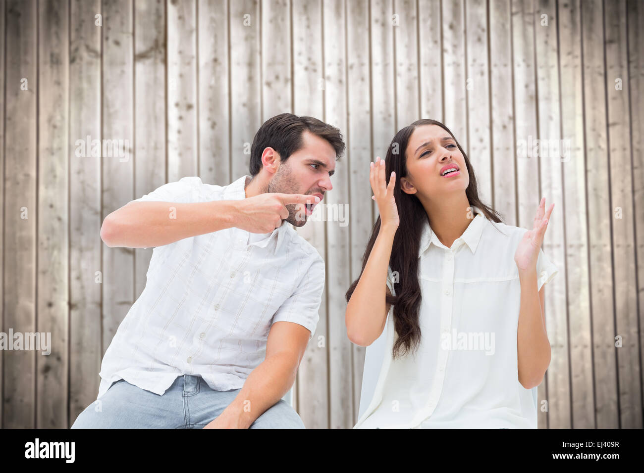 Composite image of couple sitting on chairs arguing Stock Photo