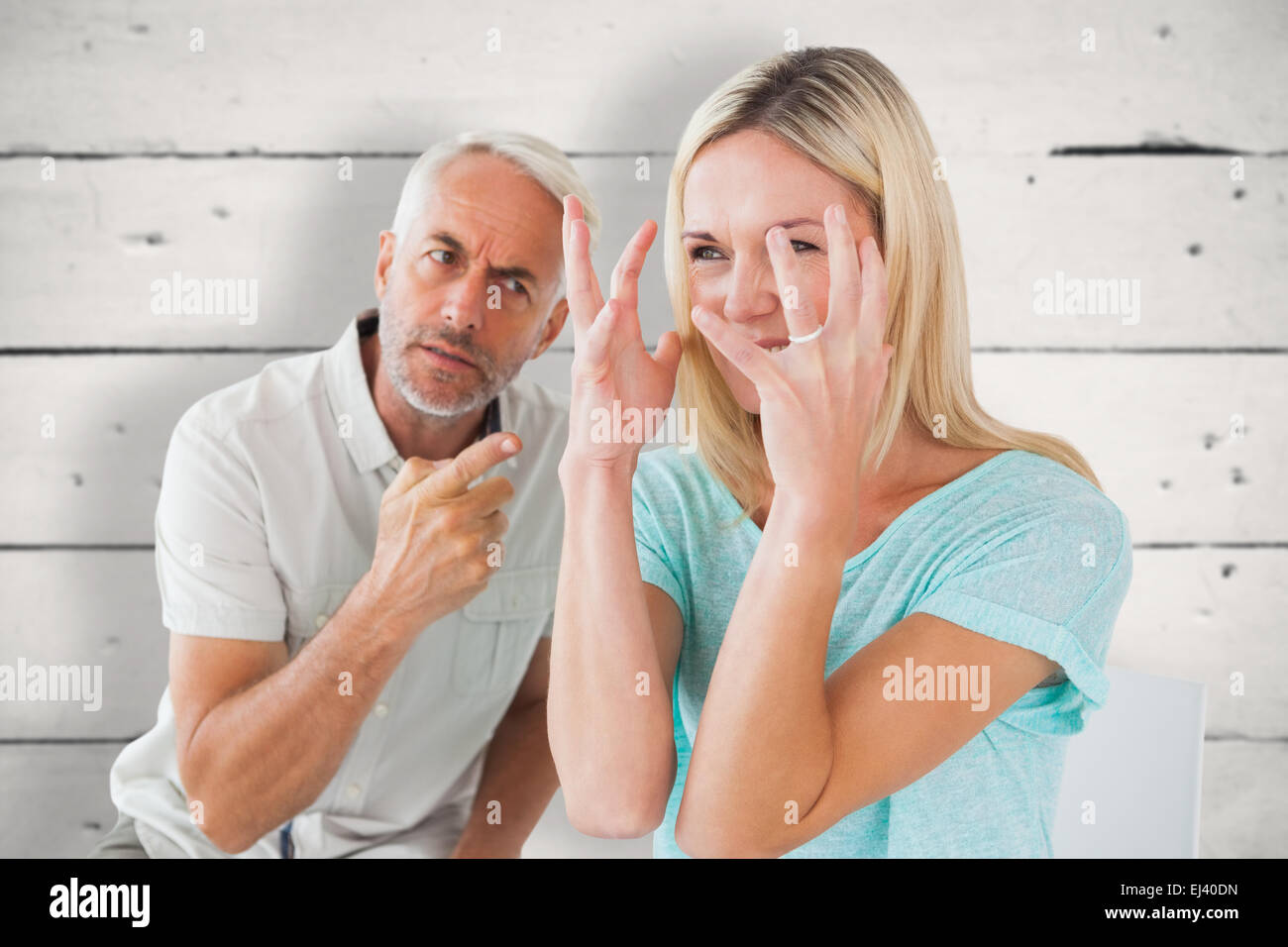 Composite image of unhappy couple sitting on chairs having an argument Stock Photo