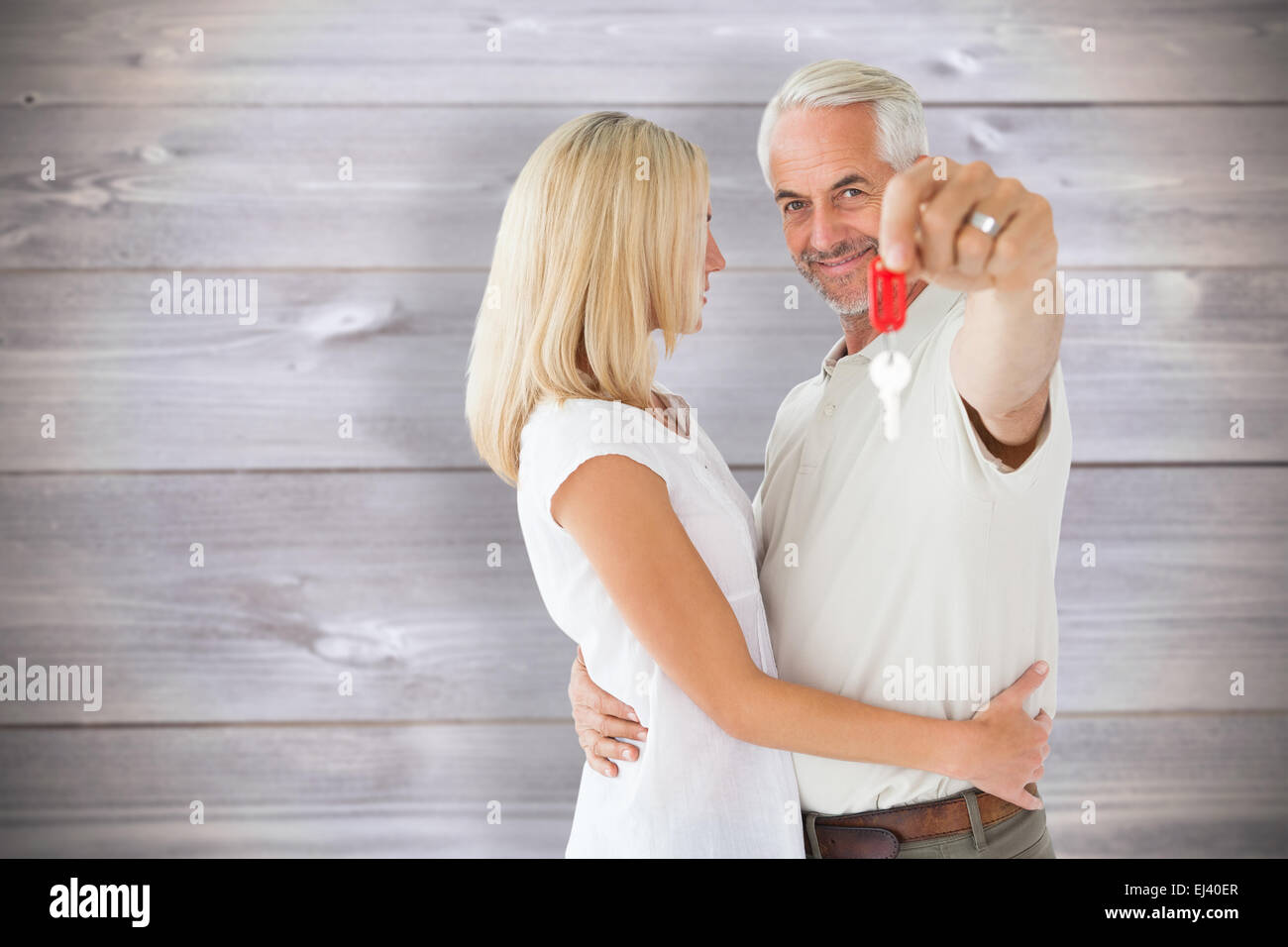 Composite image of happy couple showing their new house key Stock Photo ...