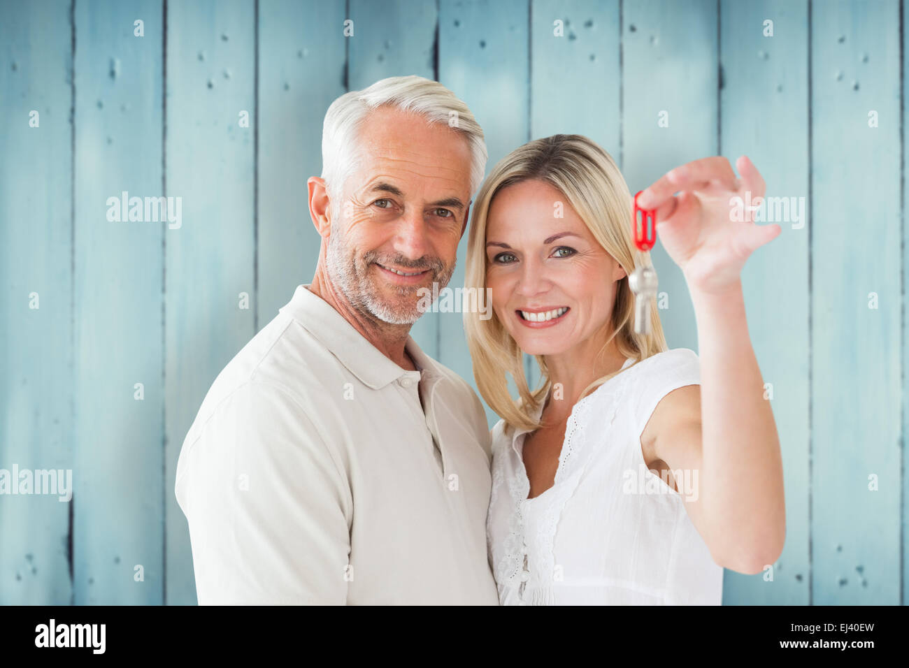 Composite image of happy couple showing their new house key Stock Photo ...