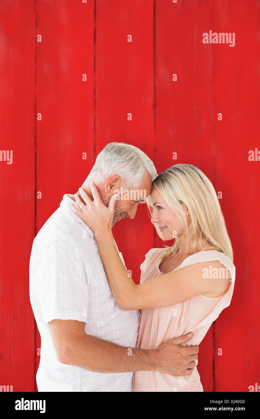 Composite image of affectionate couple standing and hugging Stock Photo