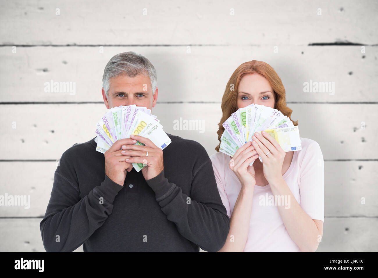 Composite image of casual couple showing their cash Stock Photo