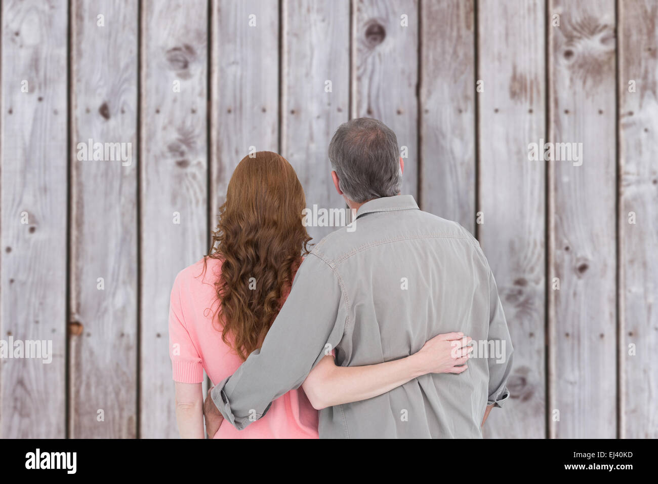 Composite image of casual couple standing arm around Stock Photo