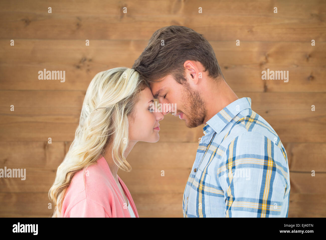 Composite image of attractive couple standing touching heads Stock Photo