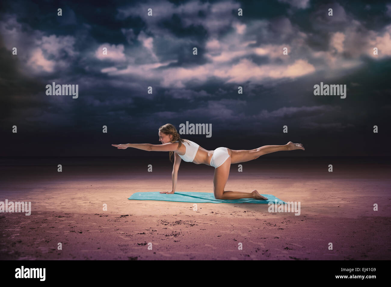 Composite image of gorgeous fit blonde in pilates pose on the beach Stock Photo