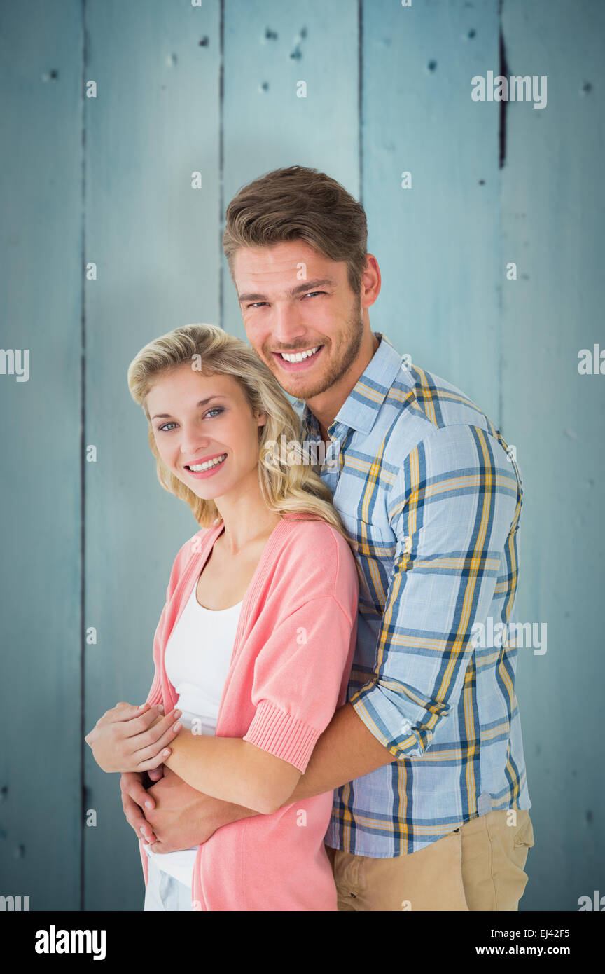 Composite image of attractive couple embracing and smiling at camera ...