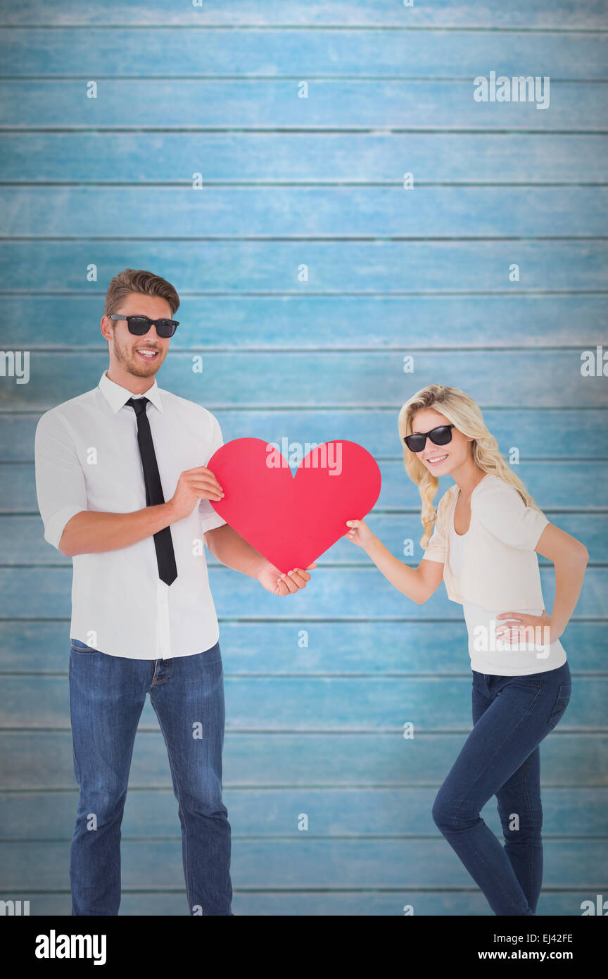 Composite image of cool young couple holding red heart Stock Photo - Alamy
