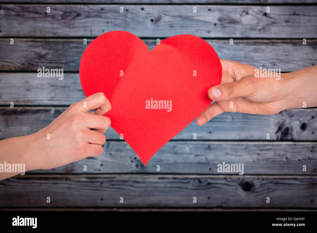 Composite image of hands holding red heart Stock Photo - Alamy