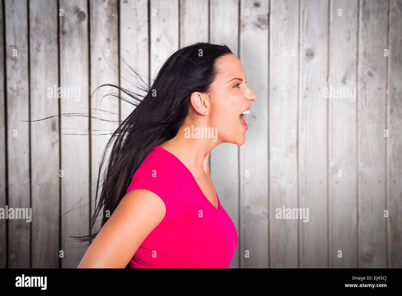 Composite image of young brunette shouting in tshirt Stock Photo