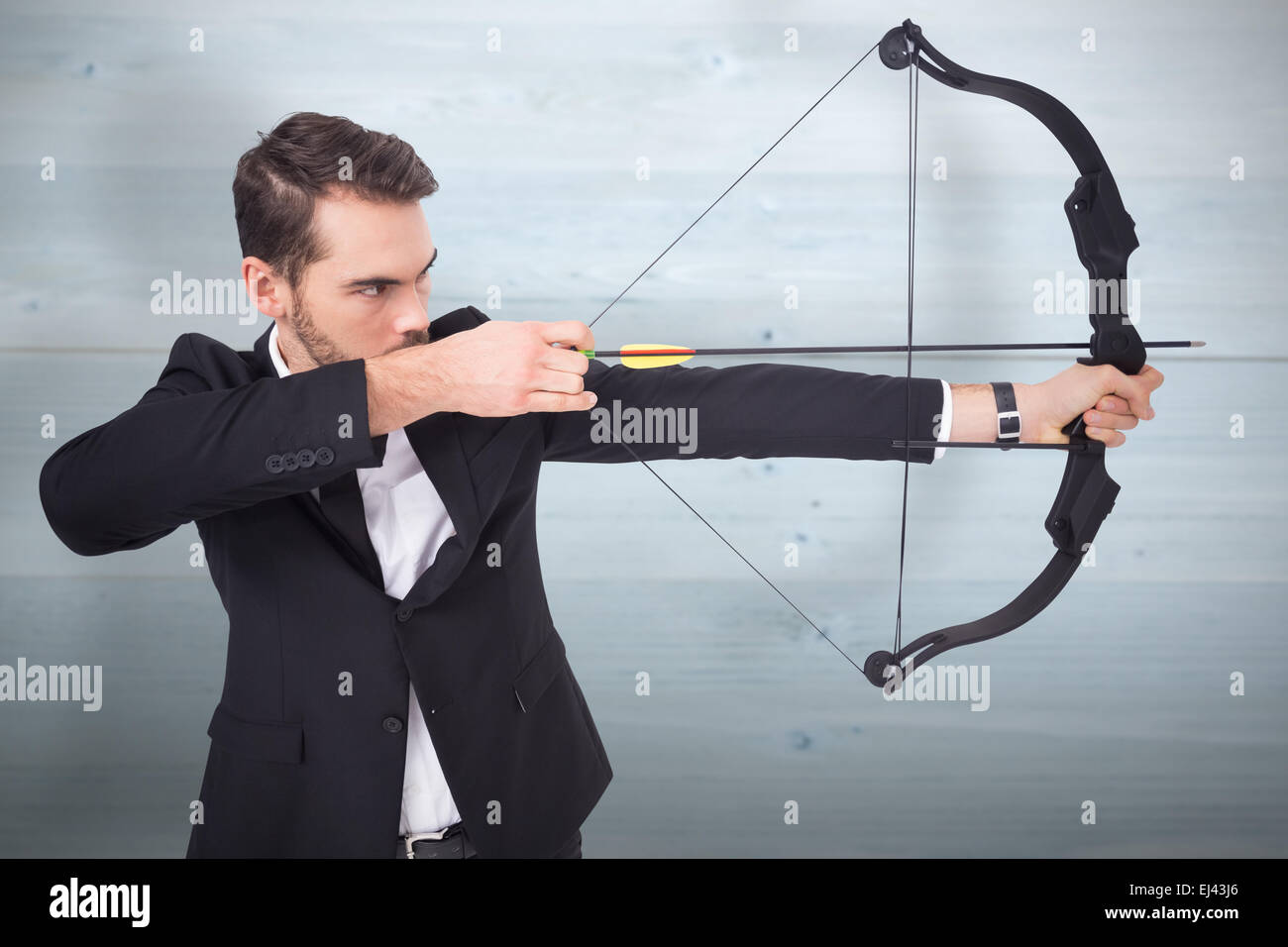 Composite image of elegant businessman shooting bow and arrow Stock Photo