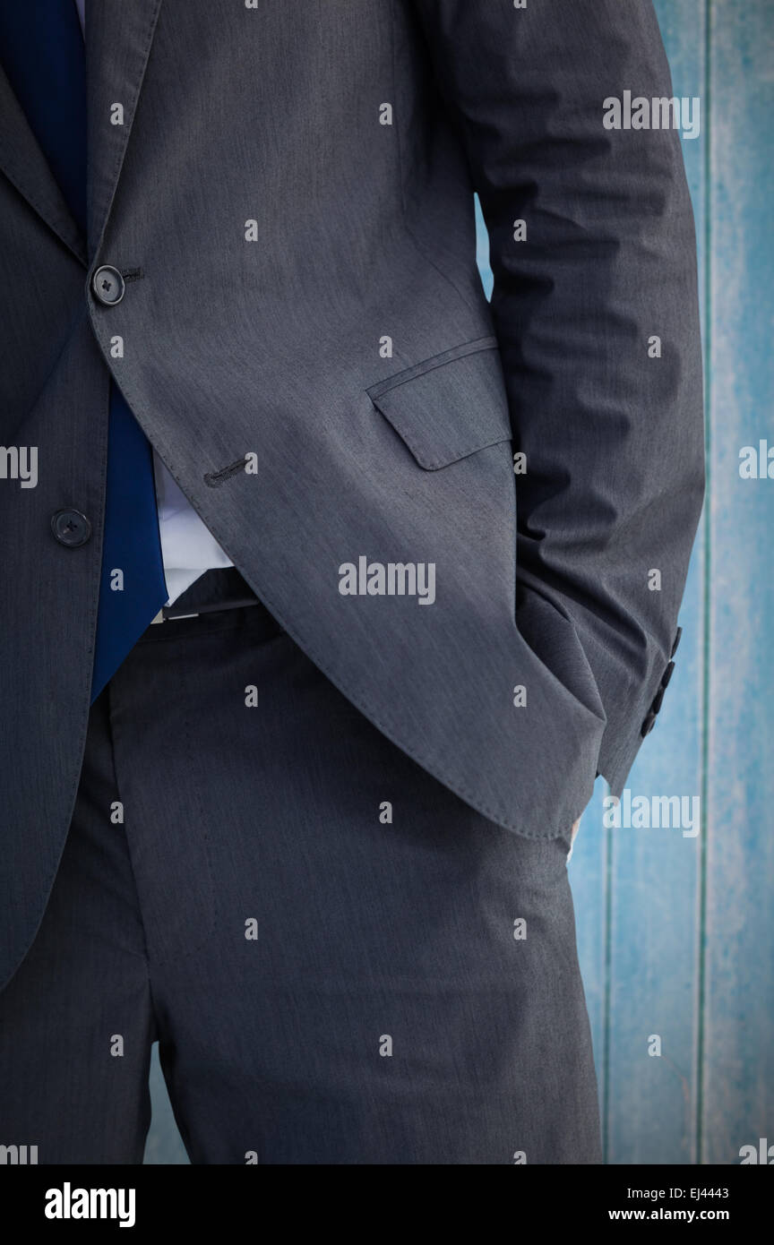 Composite image of businessman standing with hand in pocket Stock Photo