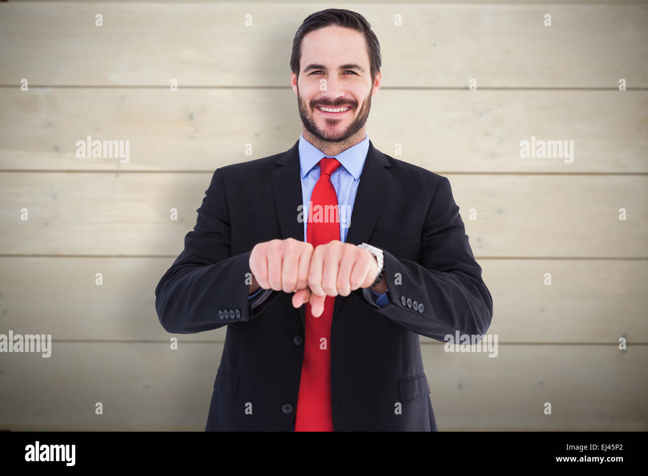 Composite image of smiling businessman with clenched fist in front of him Stock Photo