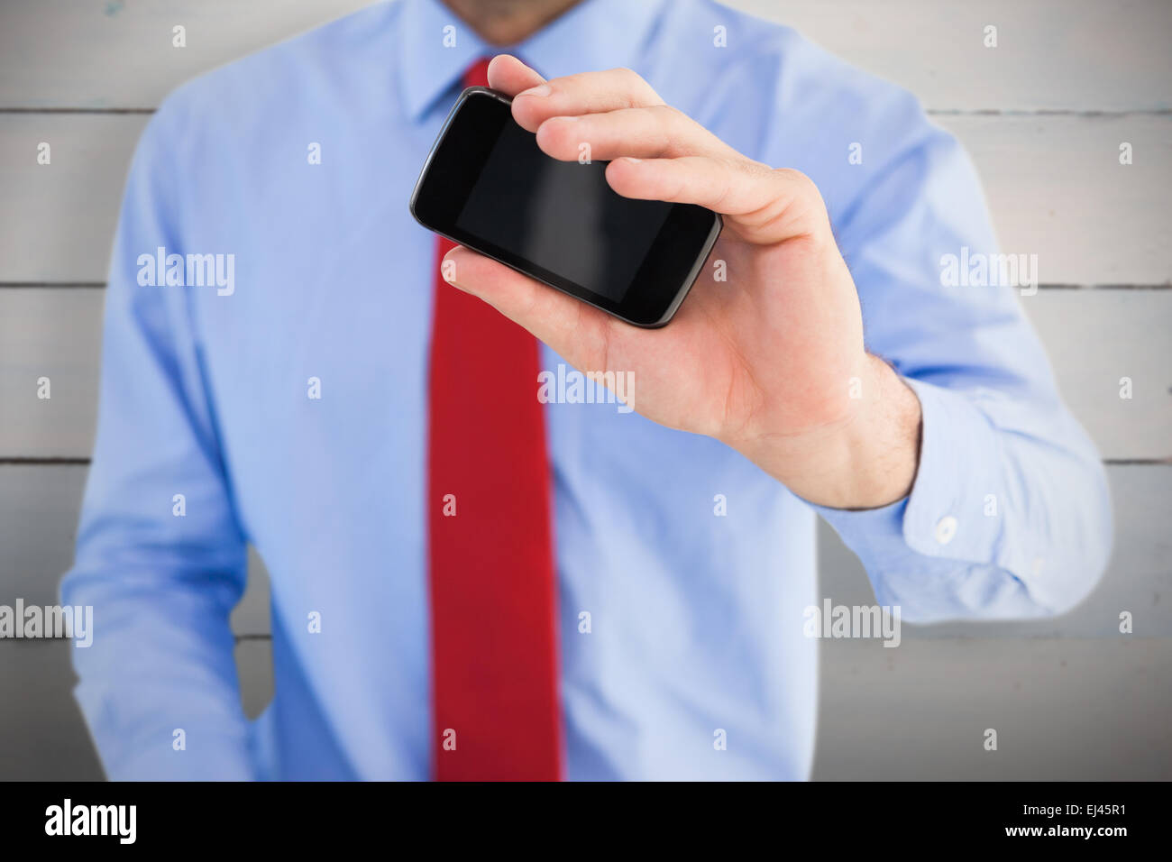 Composite image of hand of businessman showing smartphone Stock Photo