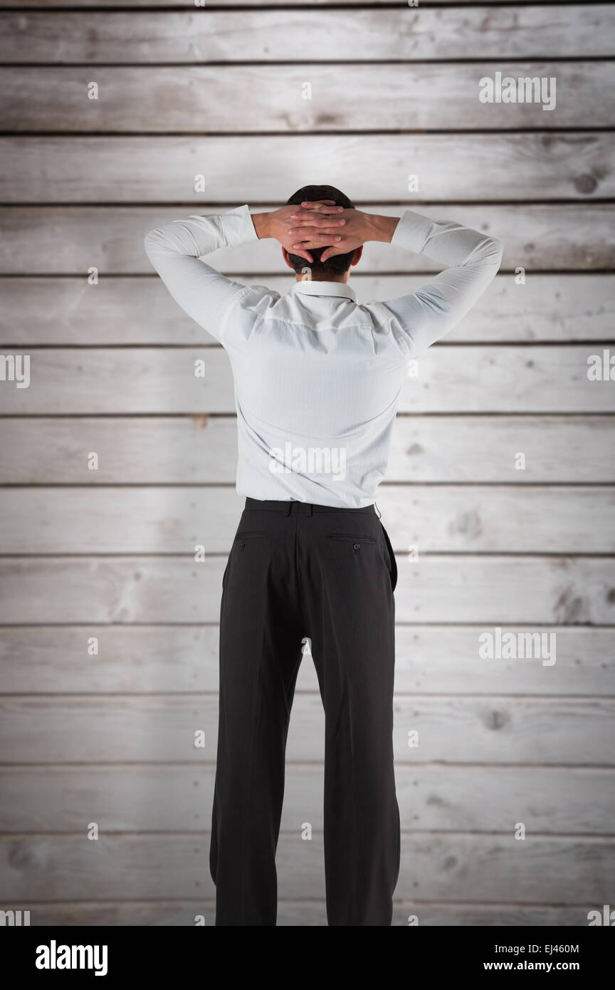 Composite image of businessman standing back to the camera with hands on head Stock Photo