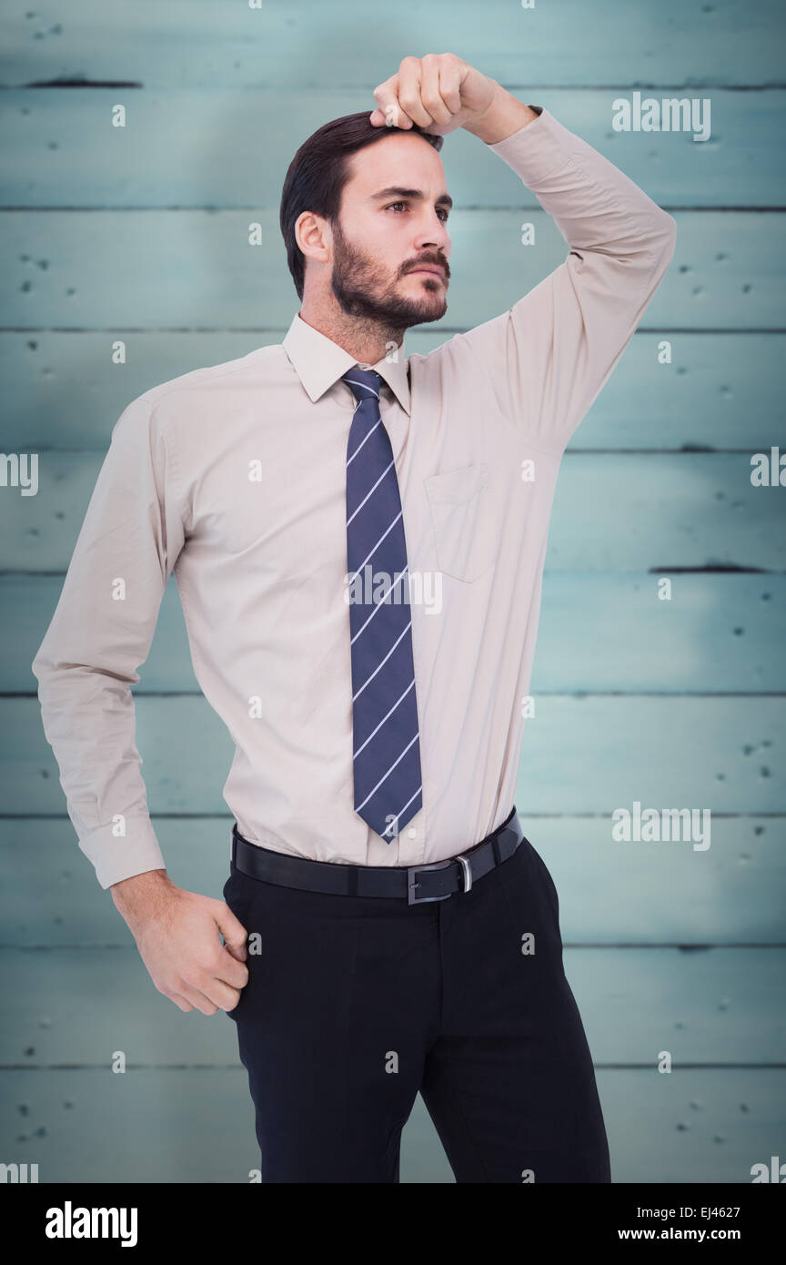 Composite image of serious businessman standing with hand on head Stock Photo