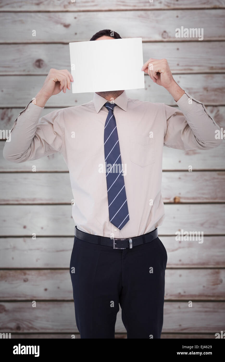Composite image of businessman showing card in front of his head Stock Photo