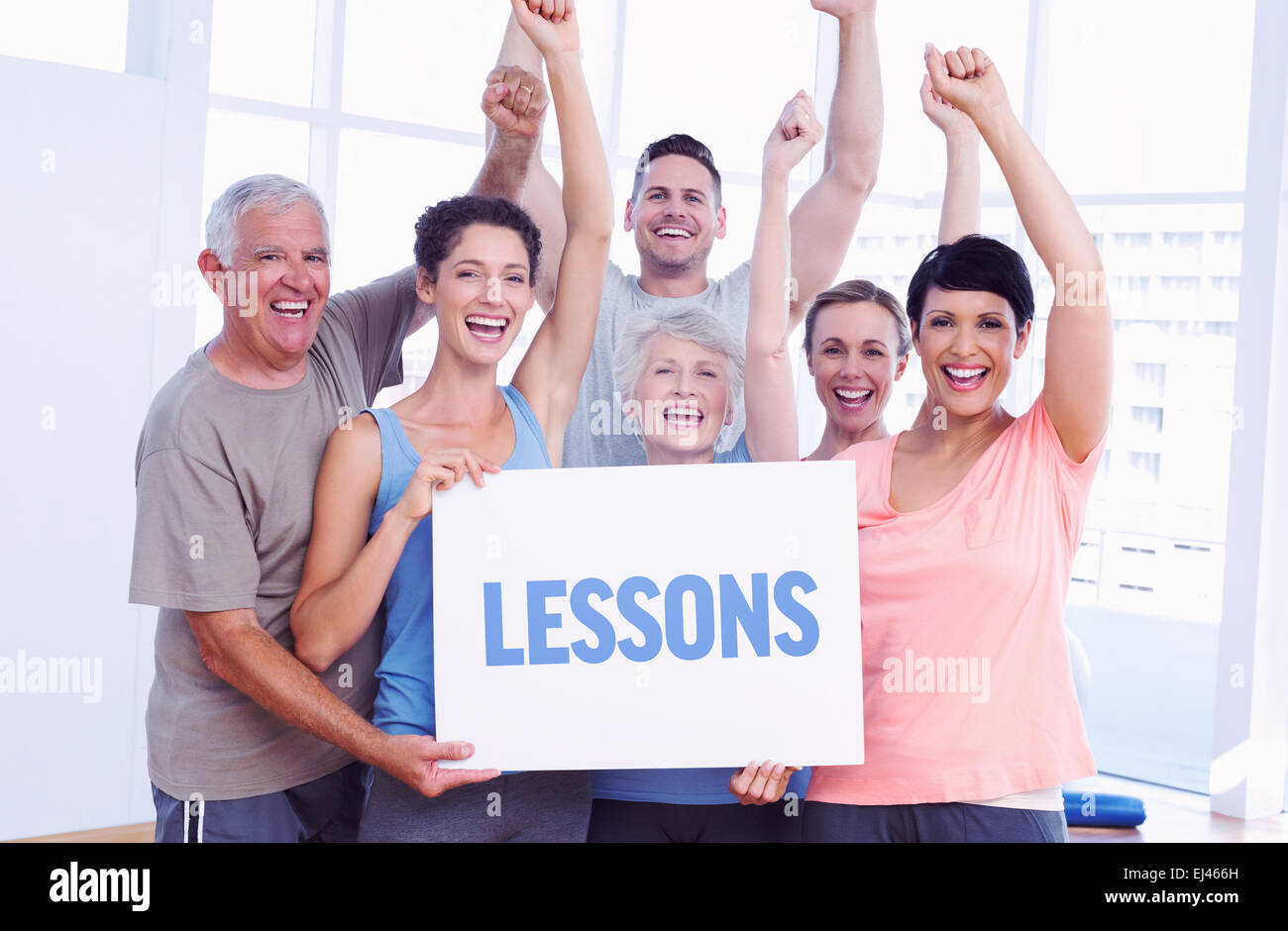 Lessons against portrait of happy fit people holding blank board Stock Photo