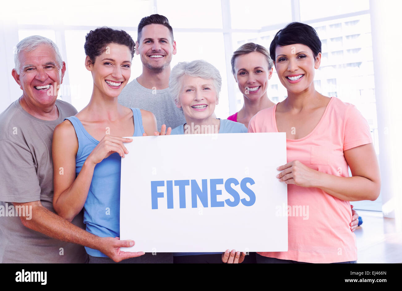 Fitness against fit people holding blank board in yoga class Stock Photo