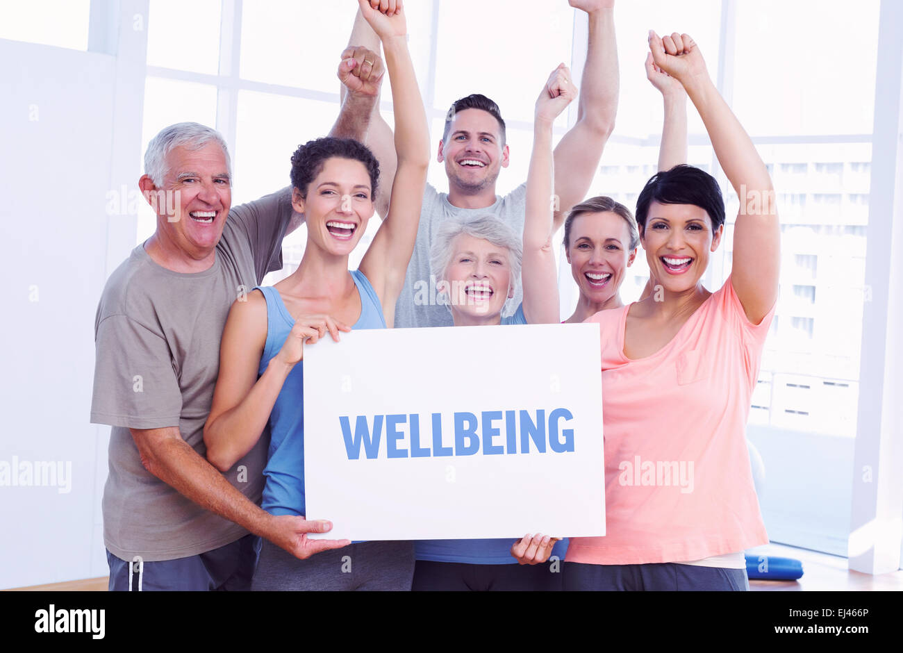 Wellbeing against portrait of happy fit people holding blank board Stock Photo