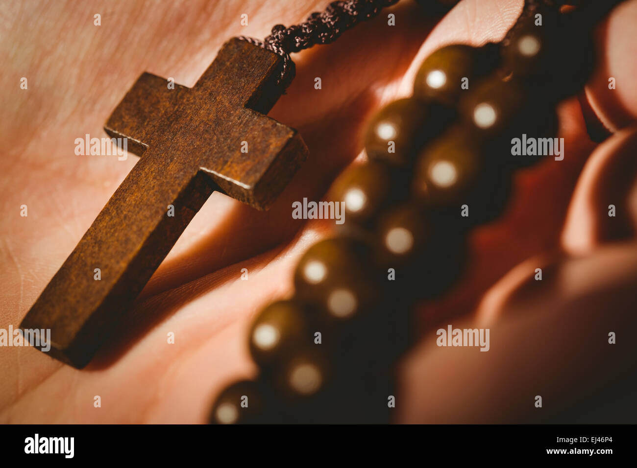 Hand holding wooden rosary beads Stock Photo