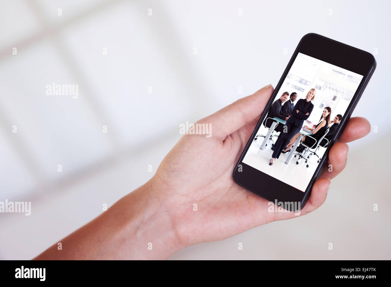 Composite image of womans hand holding black smartphone Stock Photo