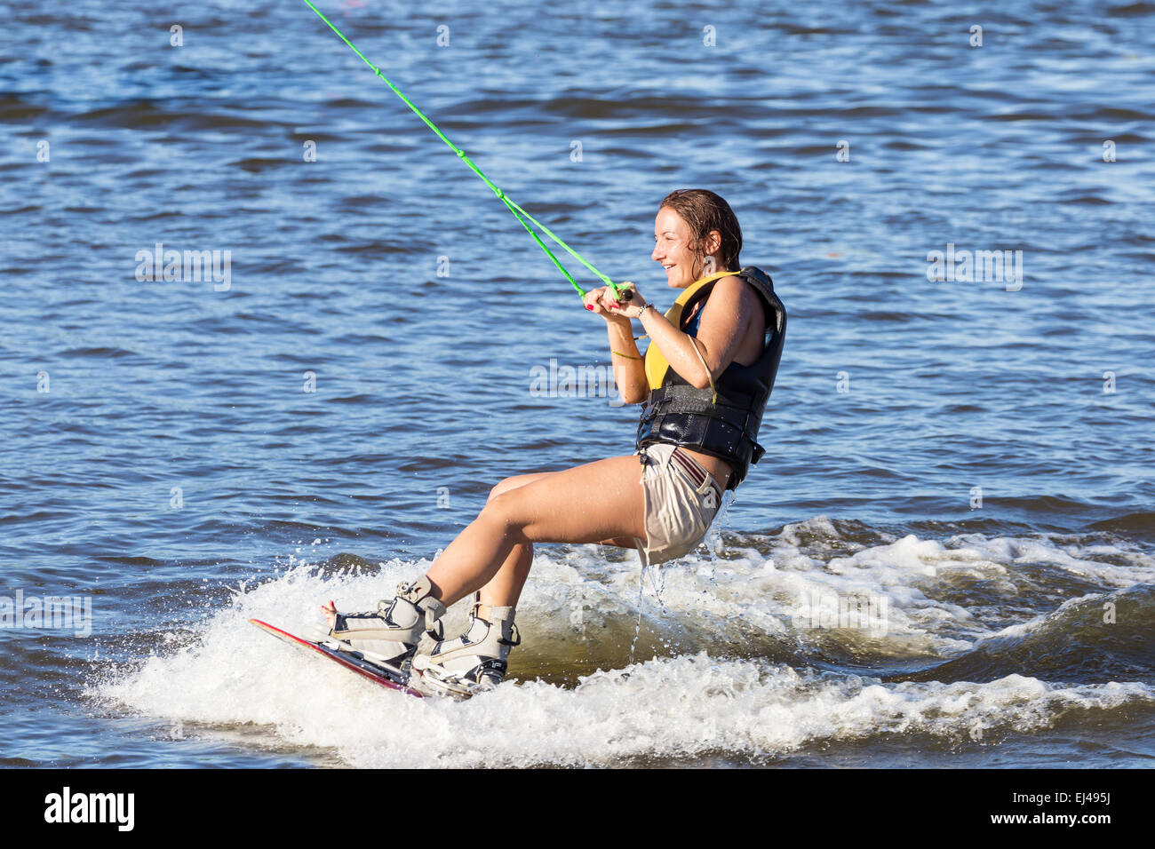 Woman study riding on a wakeboard outdoors Stock Photo