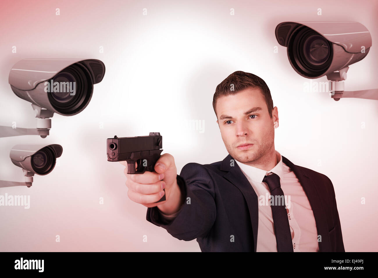 Composite image of serious businessman pointing a gun Stock Photo