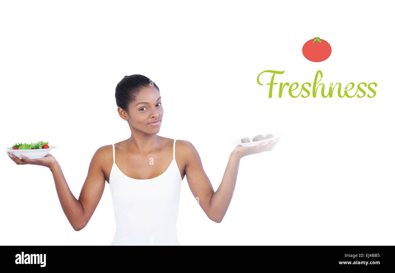Freshness against pretty woman deciding to eat healthily or not Stock Photo